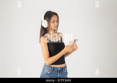 Woman in headphones looks at phone Stock Photo