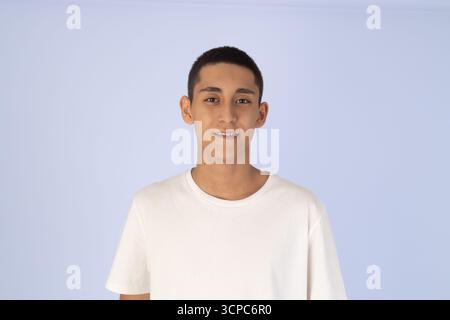 Young manis standing and looking directly at the camera with a slight smile Stock Photo