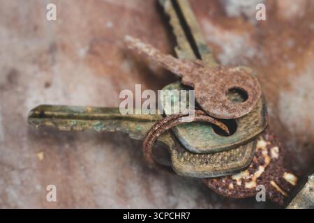 Old rusty keys in lock. Vintage door padlock with keys. Antique keys on weathered background with copy space. Security and safety concept. Stock Photo