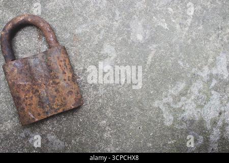 Old rusty key and lock. Vintage door padlock with key. Antique key on weathered background. Security and safety concept. Aged iron key and padlock. Stock Photo