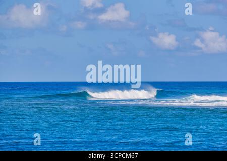 Beautiful blue ocean waves crash and splash on the horizon under sunny sky clouds. Powerful, dynamic summer seascape background for travel background Stock Photo