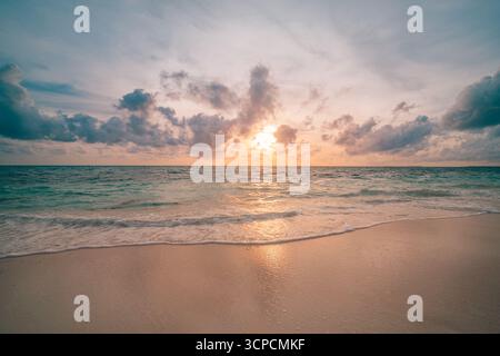 Gorgeous closeup sea sand sky sunset colorful clouds reflection on calm waves tranquil seascape beach background summer evening coastal scenery. Stock Photo