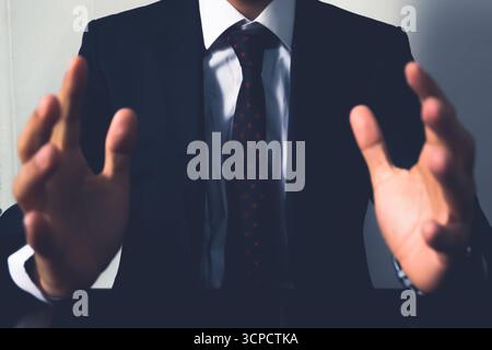 Midsection of Businessman in Suit Gesturing with Open Hands as if Holding a Virtual Object or Presenting a Concept Stock Photo