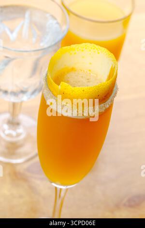 Mimosa cocktail with lemon garnish and sparkling glassware at a brunch setting Stock Photo