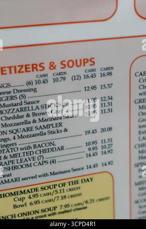 A diner menu displays details for various appetizers and soups, showcasing prices and options available for guests. Stock Photo