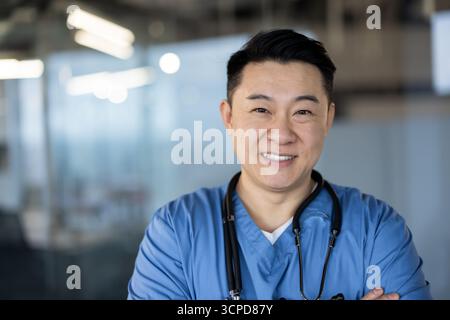 Young asian doctor in blue uniform and stethoscope pointing at anterior ...