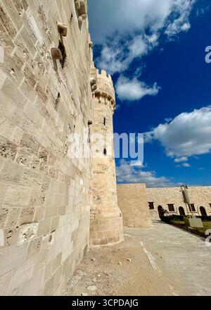 Alexandria, Egypt - Feb 13, 2025: Detailed view of fortified stone wall and tower of the medieval Citadel of Qaitbay fortress. Stock Photo