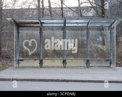 Bus stop with graffiti on the side and a heart on the wall Stock Photo