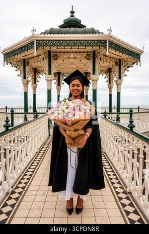 A University of Brighton Student Poses For A Photo Outdoors After Her Graduation Ceremony, Brighton, East Sussex, UK. Stock Photo