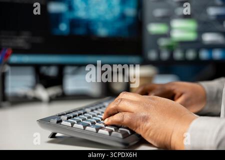 Close up of data center programmer typing on PC keyboard, using artificial intelligence neural networks. Server room expert typing code, using AI programming language on computer, configuring hardware Stock Photo