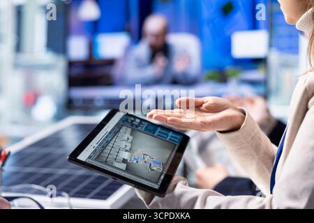 Investors evaluating photovoltaics factory production efficiency using tablet before investing, close up. Shareholders meeting with solar panels plant managers to understand business model Stock Photo