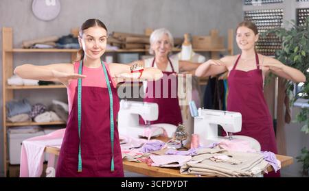team of dressmakers doing a warm-up in the workshop Stock Photo
