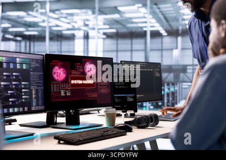 Admin in server hub establishment frightened by hacker passing firewall and stealing data. Security breach notification on monitor in data center making IT expert panic, requesting help Stock Photo