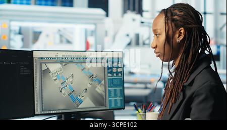 Photovoltaics factory programmer coding app monitoring system performance. Solar panels manufacturing plant system administrator writing code tracking energy production and efficiency, camera B Stock Photo