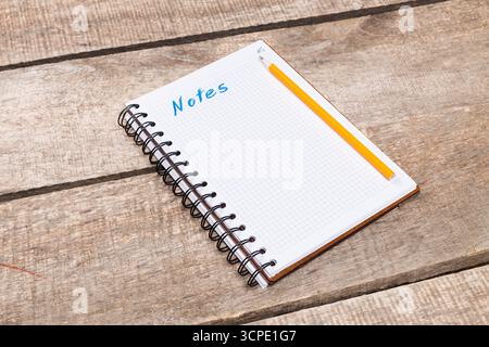 Blank notebook with pencil resting on wooden surface for taking notes and ideas Stock Photo