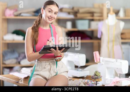 Woman dressmaker makes pattern using tablet Stock Photo