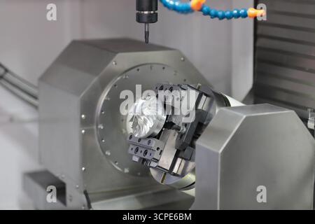 Turbine wheel processing on 5-axis milling machine.5-axis CNC milling machine with rotary table closeup. Selective focus. Stock Photo