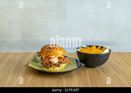 Gourmet burger with a Black Angus entrecote medallion, melted Brie   cheese, heirloom green tomato, and butter lettuce on a black sesame brioche bun Stock Photo