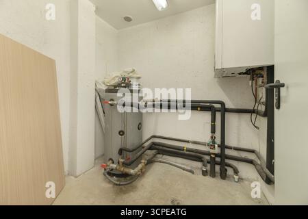 laundry room with a washer-dryer, compact boiler, and area to fold clothes immediately after washing Stock Photo