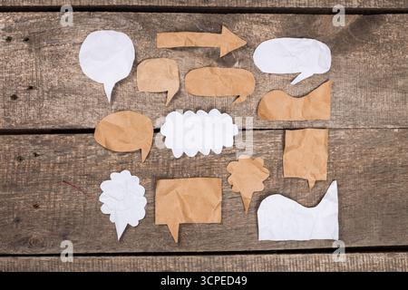 Creative paper shapes arranged on a wooden surface for communication and expression Stock Photo