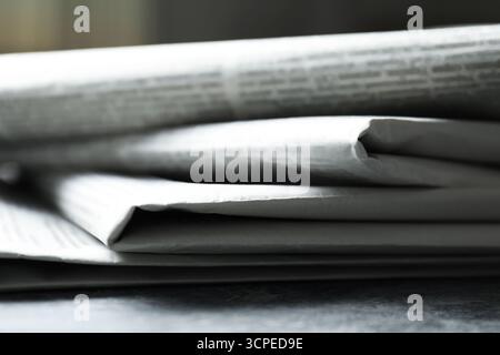 Stack of newspapers on grey table, closeup Stock Photo