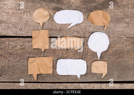 Crafty paper speech bubbles arranged on wooden surface for creative communication Stock Photo