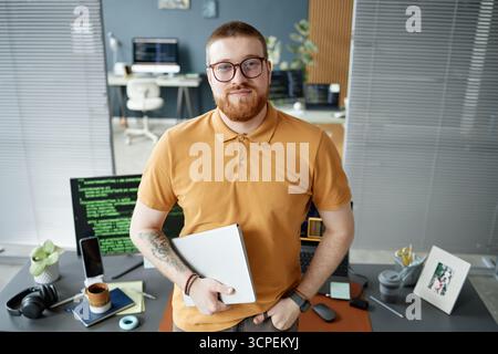 Portrait of Young Adult Man Holding Tablet Standing in Office Stock Photo