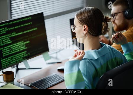 Young Woman Programming on Computer Beside Young Man Working Stock Photo
