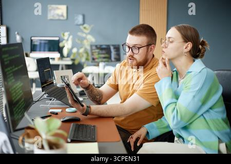 Young Adult Man Explaining Project to Young Adult Woman Stock Photo
