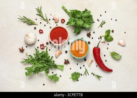 Composition with herbs and bowls of spices on white grunge background Stock Photo
