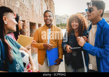 Young diverse students smiling outdoors at university campus. Friendship education and inclusion concept Stock Photo
