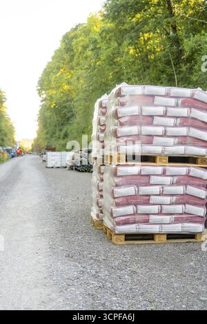 Pallets with building materials on a gravel road surrounded by forest, Hermann Hessebahn construction site, Calw, Germany Stock Photo