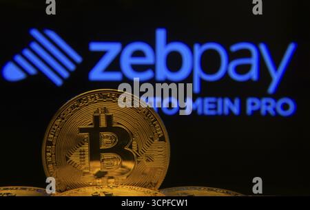 Dhaka, Bangladesh- 04 April 2025: Close-up of Bitcoin coins with the ZebPay logo visible on a screen in the background Stock Photo