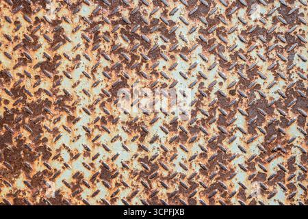 Close-up of a severely worn and rusty metal checker plate, perfect for a unique art or grunge background Stock Photo