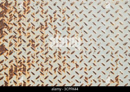 Close-up of a severely worn and rusty metal checker plate, perfect for a unique art or grunge background Stock Photo