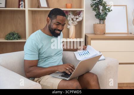 Young university student, freelancer business man, working at home on laptop computer, testing new innovative technology and online internet tools whi Stock Photo