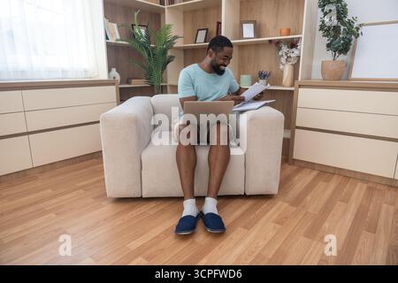 Young university student, freelancer business man, working at home on laptop computer, testing new innovative technology and online internet tools whi Stock Photo