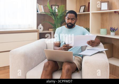Young university student, freelancer business man, working at home on laptop computer, testing new innovative technology and online internet tools whi Stock Photo