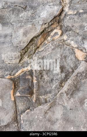 Chic vertical background of grey stone of natural origin. rough cracks in the rock. gray texture of natural stone Stock Photo