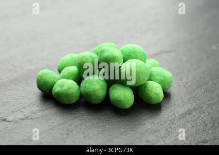 Pile of delicious wasabi coated peanuts on dark textured table, closeup Stock Photo