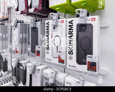 Poznan, Poland - September 20, 2025: Well-lit retail setting showcasing various transparent and dark protective covers for popular mobile devices, sec Stock Photo