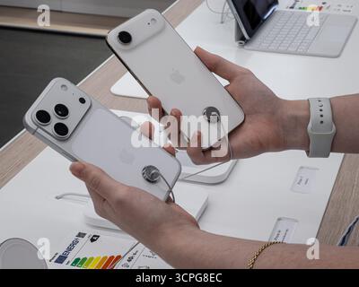 Poznan, Poland - September 20, 2025: iPhone 17 Pro and iPhone Air, white smartphones, held by a person exploring new mobile technology within a retail Stock Photo