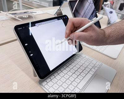 Poznan, Poland - September 20, 2025: Close-up of a hand interacting with an Apple iPad, using the Pencil for digital design on a bright store display Stock Photo