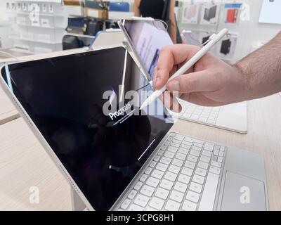 Poznan, Poland - September 20, 2025: Procreate, displayed on tablet, used by hand with stylus for illustrating digital concepts in store setting Stock Photo