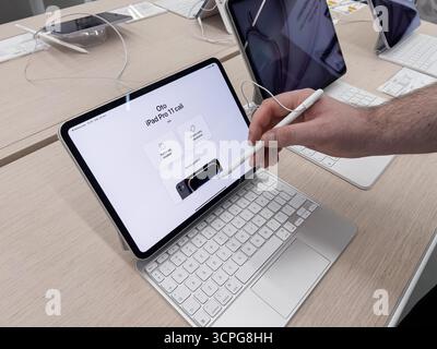 Poznan, Poland - September 20, 2025: Hand interacts with Apple iPad Pro 11 screen via Apple Pencil, Magic Keyboard, showing powerful digital capabilit Stock Photo