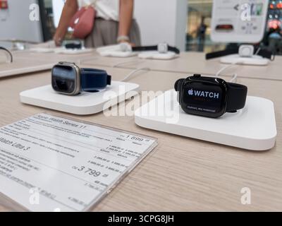 Poznan, Poland - September 20, 2025: Apple Watch 11 and Apple Watch Ultra 3 smartwatches are displayed for sale on individual white charging stands Stock Photo
