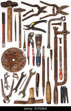 Flat lay of old hand tools on white background. Large collection of various rusty tools and bits arranged on white. Stock Photo