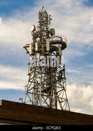 Telecommunications tower with multiple antennas and satellite dishes on a rooftop on the Telephone Exchange in York, North Yorkshire, England, UK Stock Photo