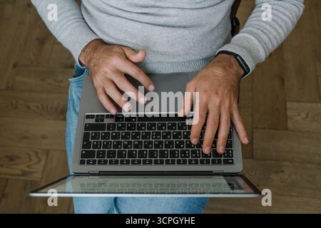 Top view of male hands typing on laptop keyboard, workspace concept Stock Photo