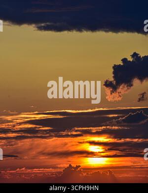 Warm sunset light paints the sky with soft cloud textures and magical colors, perfect for nature, travel, or background concepts. Stock Photo
